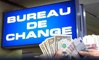 Bureau de change avec affichage lumineux et devises étrangères.