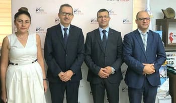 Quatre professionnels en costume lors d'une réunion d'affaires.