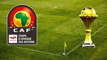 Trophée de la CAN sur un terrain de football vert.