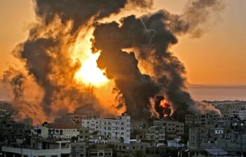 Fumée et explosions lors d'un conflit à Gaza au coucher du soleil.