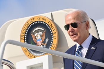 Joe Biden portant des lunettes de soleil descend de l'avion présidentiel.