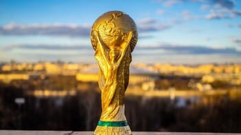Trophée de la Coupe du Monde 2030 en or avec un fond urbain.