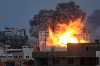 Explosion massive avec fumée noire et flammes dans une zone urbaine.