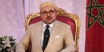 Homme politique marocain en costume beige, siège royal, drapeau du Maroc en arrière-plan.