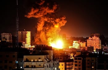 Explosion massive avec une grande colonne de fumée dans une ville urbaine.