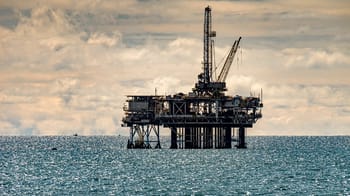 Plateforme pétrolière en mer sous un ciel nuageux.