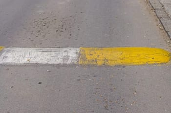 Marquage au sol jaune et blanc usé sur la route en Algérie.