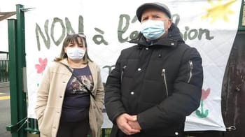 Deux personnes portant un masque lors d'une manifestation pour les droits des migrants.