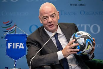 Le président de la FIFA tenant un ballon de football lors d'une conférence.