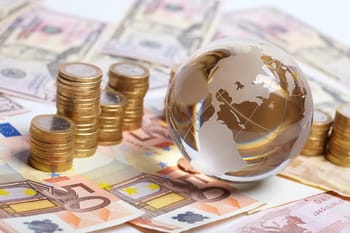 Globe en verre sur des billets et pièces de monnaie euro.