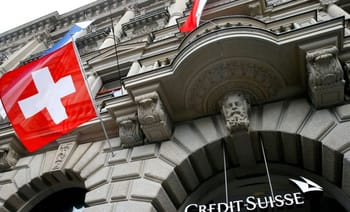 Façade du bâtiment Credit Suisse avec drapeaux suisses.