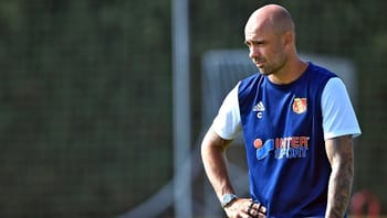 Entraîneur de football en entraînement avec maillot bleu et logo de club.