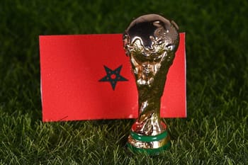 Trophée de la Coupe du Monde avec drapeau marocain en arrière-plan.