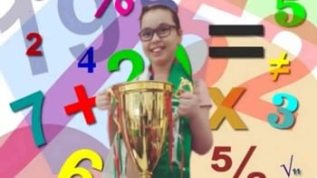 Jeune fille souriante avec trophée, entourée de chiffres colorés.