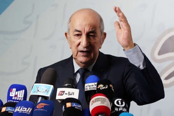 Homme politique algérien parlant aux médias lors d'une conférence.