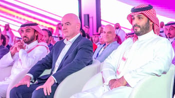 Gianni Infantino assis lors d'une conférence ou événement officiel.
