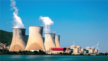 Centrale nucléaire avec tours de refroidissement et éoliennes au Maroc.
