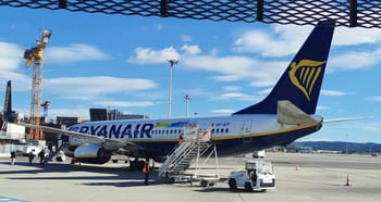 Avion Ryanair stationné à l'aéroport avec personnel au sol.