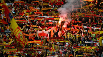 Supporters du RC Lens avec écharpes et fumigènes lors d'un match.