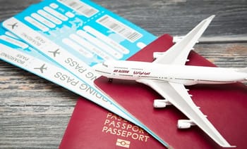 Avion, passeport et billets d'avion sur une table en bois.