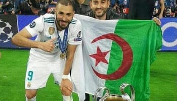 Joueurs algériens avec drapeau national et trophée de football.