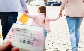 Famille avec enfant tenant un document officiel de voyage ou de résidence.