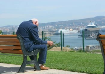 Homme âgé assis sur un banc, regardant la mer à Alger.
