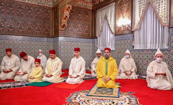 Groupe de personnes en tenue traditionnelle lors d'une cérémonie religieuse au Maroc.