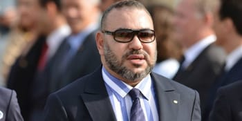 Homme en costume avec lunettes de soleil lors d'un événement officiel.