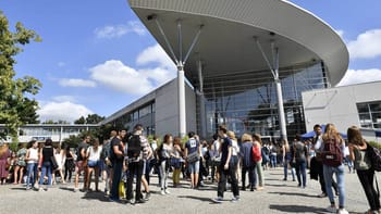 Groupe d'étudiants marocains devant une université moderne en plein jour.
