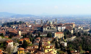 Vue de Bergame avec ses bâtiments historiques et ses collines environnantes.