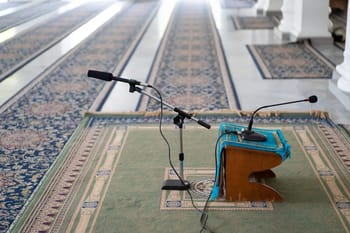 Microphone et pupitre dans une mosquée, prêt pour la prière ou un discours.
