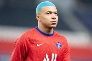 Kylian Mbappe avec cheveux teints en bleu, portant le maillot du PSG.