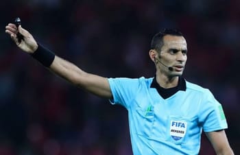 Arbitre FIFA en pleine décision lors d'un match de football.