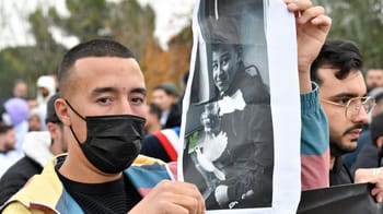 Jeune homme portant un masque lors d'une manifestation en mémoire d'Aymen.