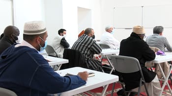 Imams en réunion dans une salle de conférence en France.