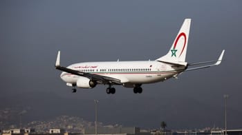 Avion Royal Air Maroc en vol avec ciel nuageux en arrière-plan.