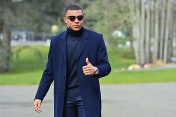 Kylian Mbappé en costume, montrant son style d'homme d'affaires.