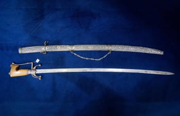 Épée ancienne avec étui décoré et fourreau en métal.