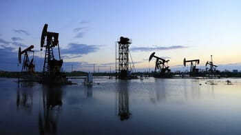 Pétroleurs en mer Rouge avec pompes et plateformes en silhouette.
