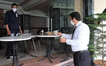 Deux restaurateurs portant des masques dans un restaurant moderne.