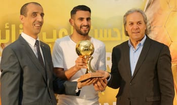 Rabah Madjer et deux autres hommes lors d'une cérémonie de remise de trophée.