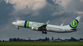 Avion Transavia en vol dans un ciel nuageux.