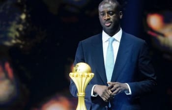 Yaya Touré en costume avec un trophée lors d'une cérémonie.