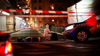 Scène d'une attaque au couteau près de la Tour Eiffel, police et témoins présents.