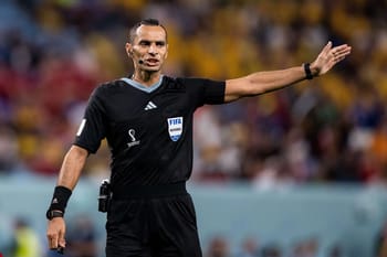 Arbitre de football professionnel en pleine décision lors de la CAN 2023.