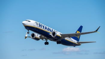 Avion Ryanair en vol dans un ciel bleu clair.
