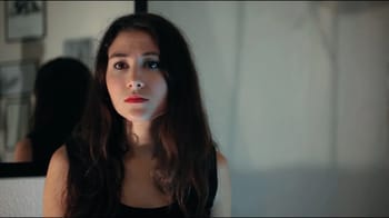 Femme avec maquillage artistique et expression sérieuse.