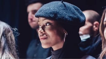 Femme portant un béret noir lors d'une rencontre sportive ou médiatique.