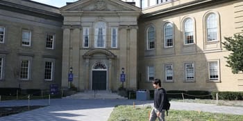 Jeune étudiant avec sac à dos devant une université historique.